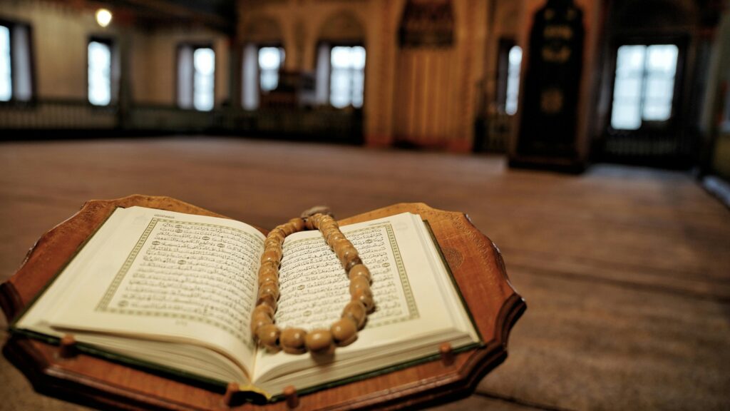 Open Quran with prayer beads in a historic Travnik mosque, symbolizing Islamic faith.