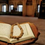 Open Quran with prayer beads in a historic Travnik mosque, symbolizing Islamic faith.