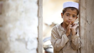 <p>
	A boy leans against the door of his ramshackle home.</p>