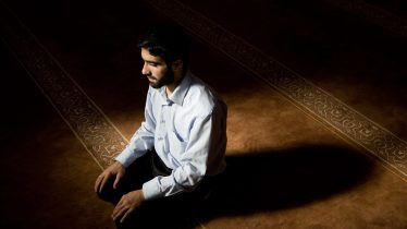 Young muslim man praying in mosque